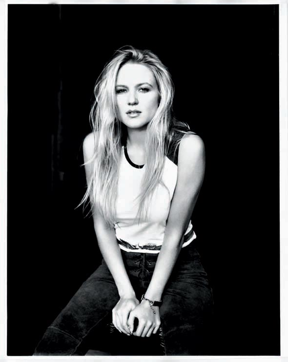 Black and white portrait of Jewel sitting on a stool